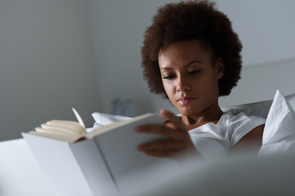 woman in bed writing in journal