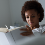 woman in bed writing in journal