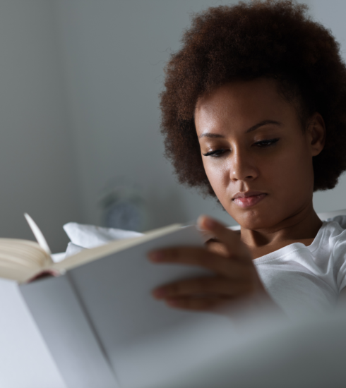 woman in bed writing in journal