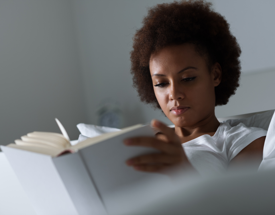 woman in bed writing in journal